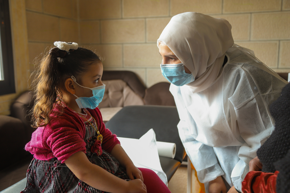 Infirmière MSF en interaction avec une petite fille pour un vaccin de routine.