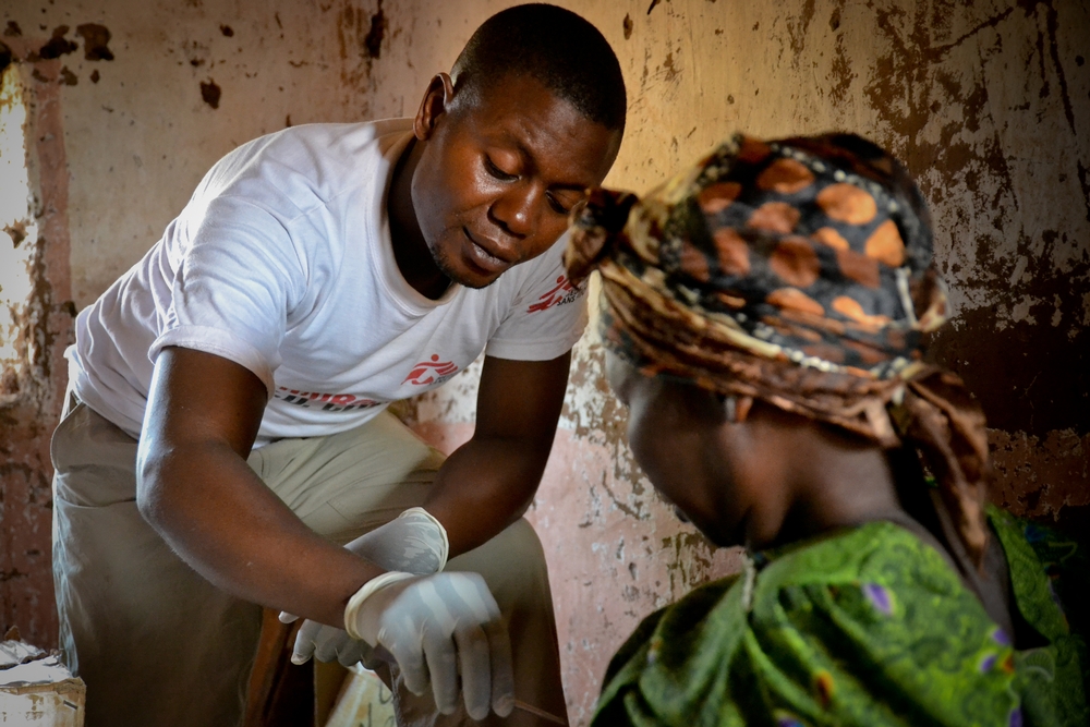L’infirmier Amos Kakule change les pansements d’une femme blessée au centre de santé de Sidi, dans la province d’Equateur en RDC. © Sandra Smiley/MSF