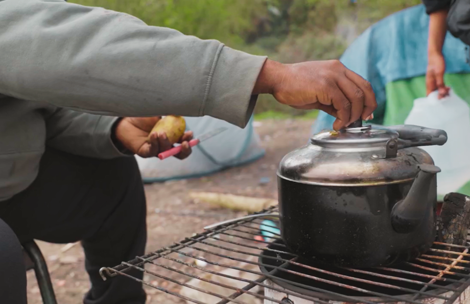 personne cuisinne sur un feu improvisé