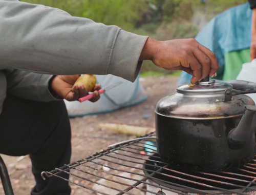 personne cuisinne sur un feu improvisé